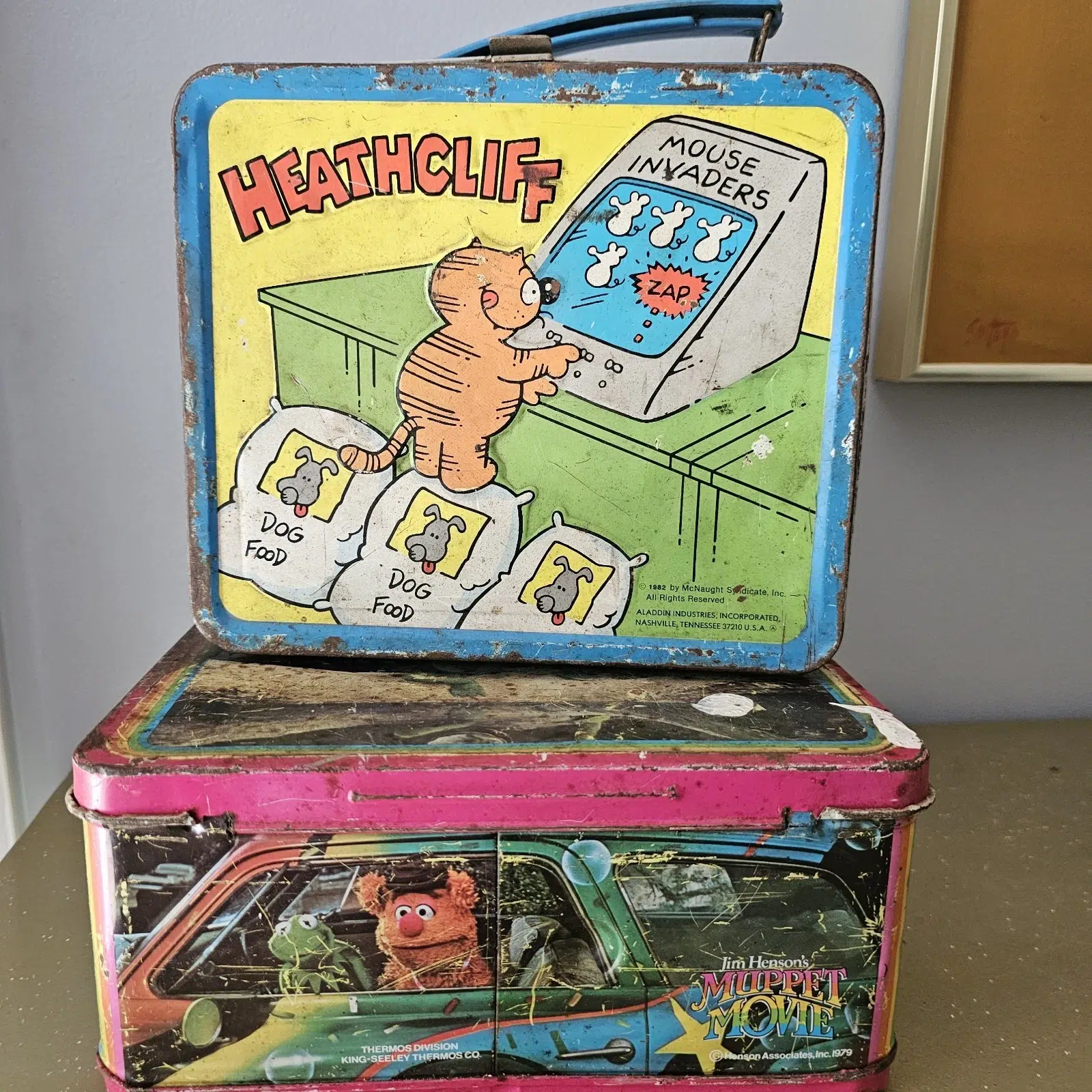 Stack of vintage metal lunchboxes featuring Heathcliff (1982) and Jim Henson’s The Muppet Movie (1979)