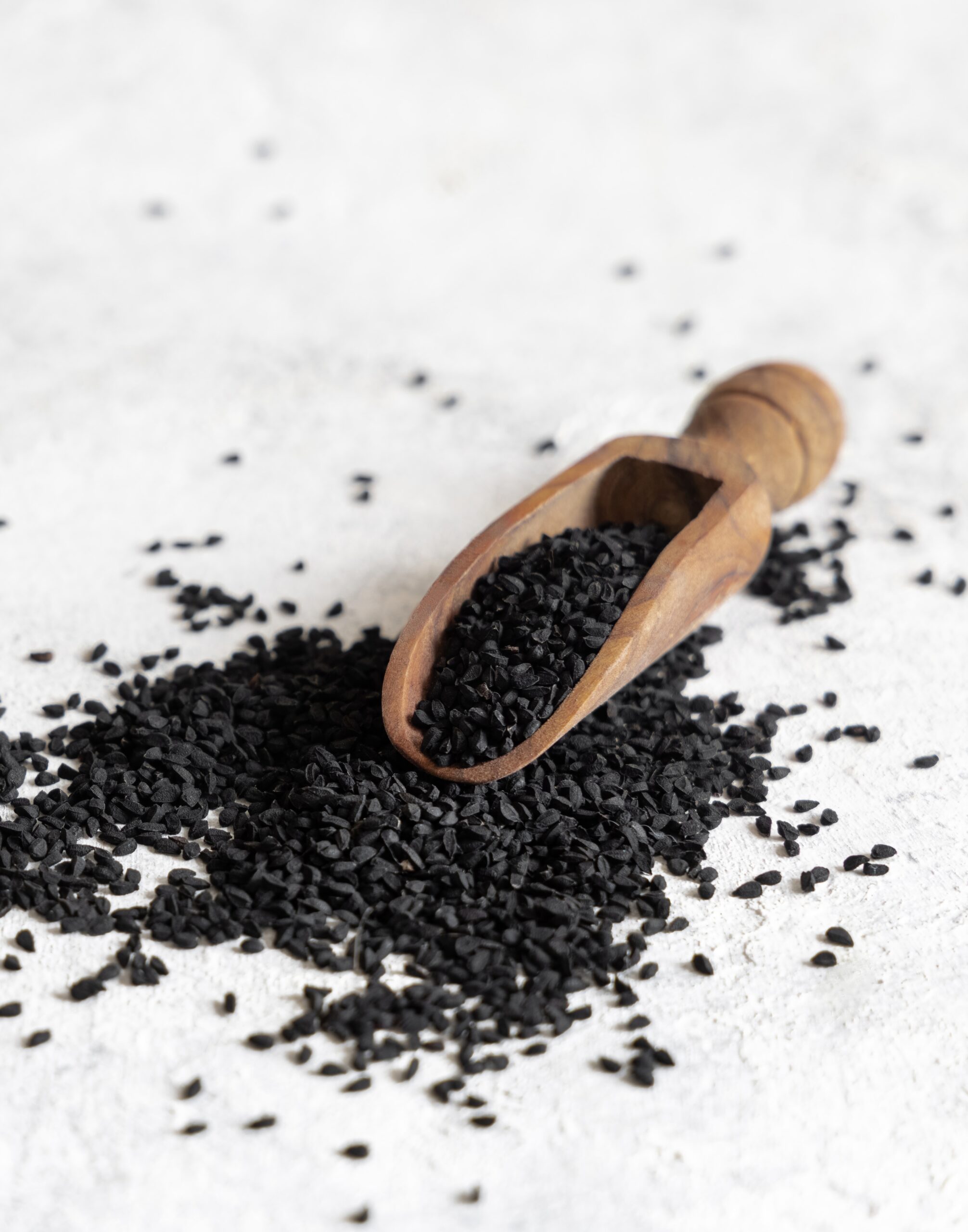 Close-up of Kalonji seeds, also known as nigella seeds, showing their black, teardrop shape and matte texture.