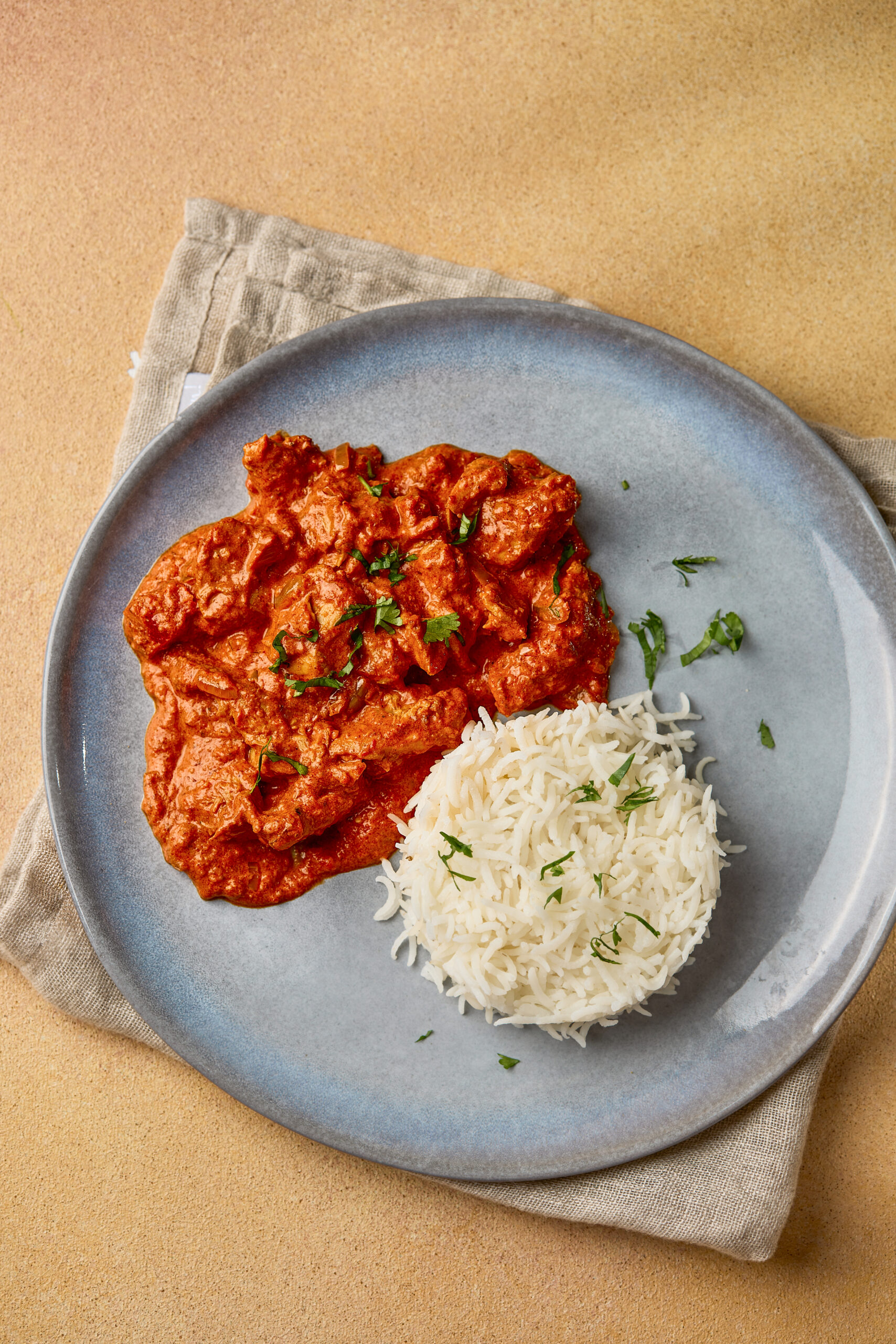Butter Chicken served with basmati rice in a plate, ready to eat.