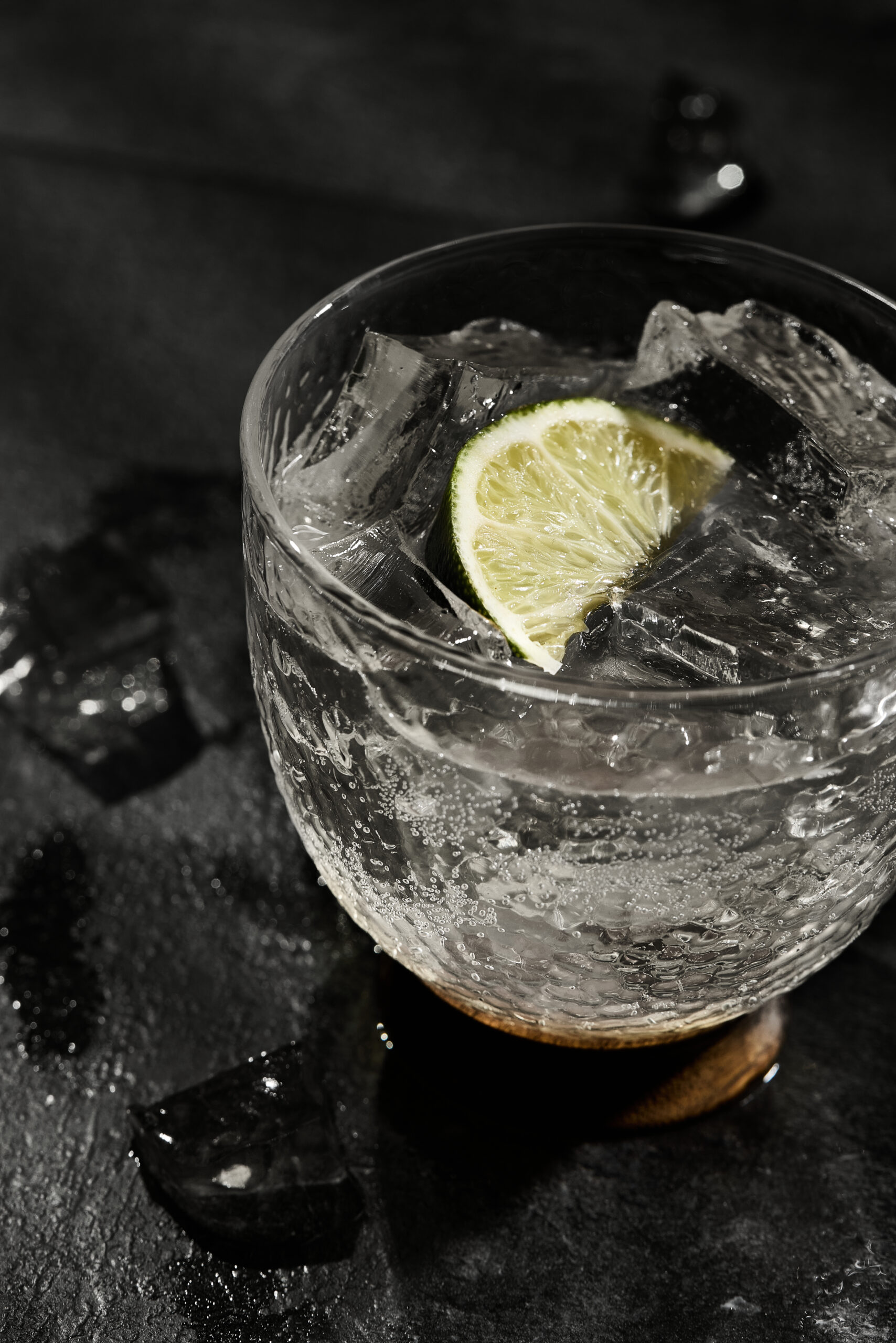 Chilled lime soda with ice, and lime wedges served on a summer afternoon