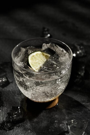 Glass of lime soda with ice cubes, fresh lime slices, served as a cooling Indian summer drink