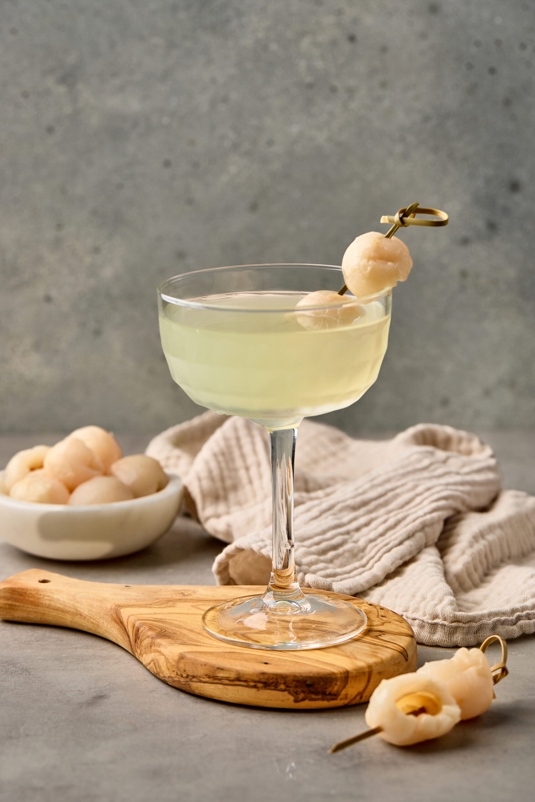 Lychee Martini served in a chilled martini glass, garnished with a whole lychee.