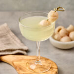 Lychee Martini served in a chilled martini glass, garnished with a whole lychee.
