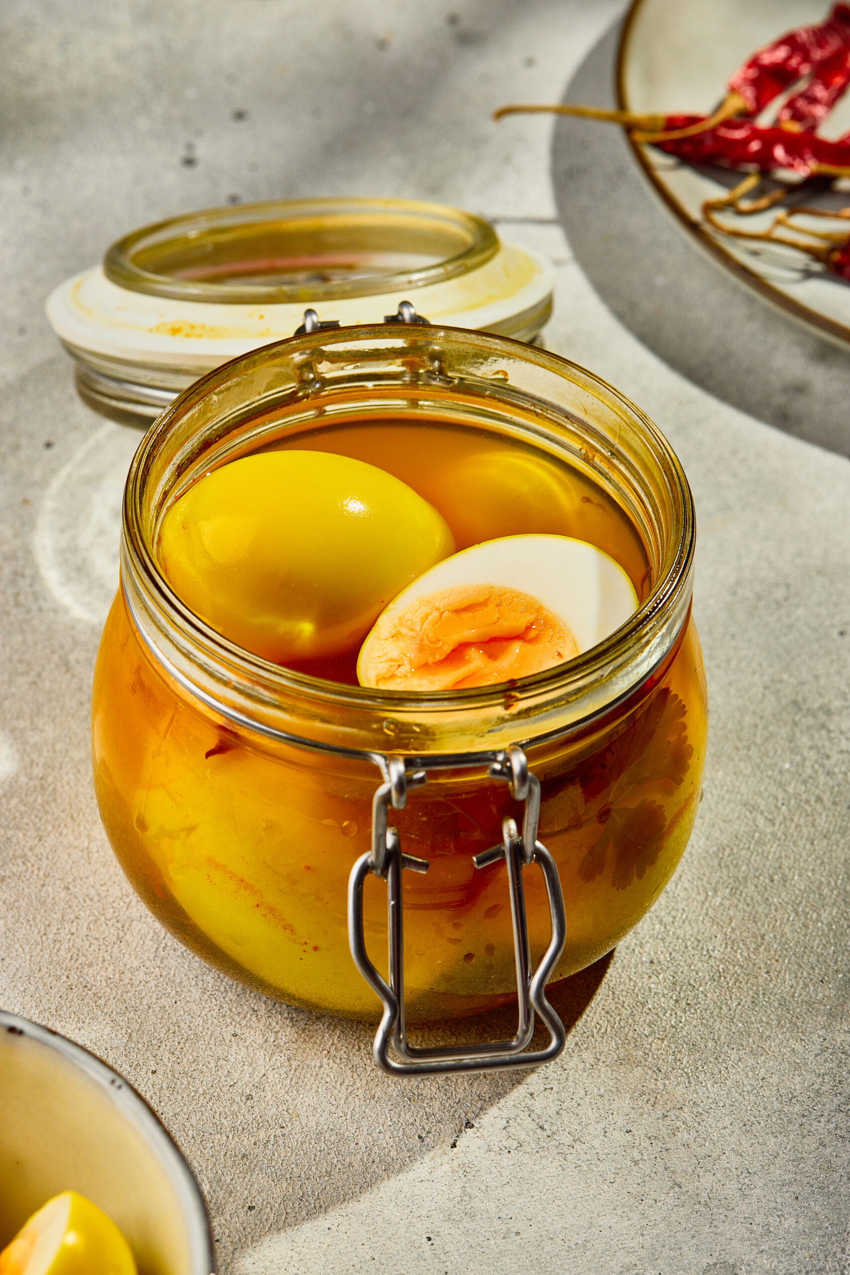 Pickled eggs in a glass jar with vinegar brine, spices.