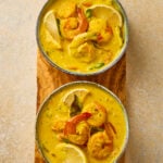 Prawn Moilee served in a bowl with creamy coconut curry, garnished with curry leaves and green chilies