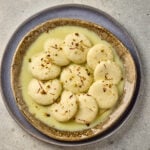Ras Malai served in a bowl with saffron milk, garnished with pistachios and almonds.