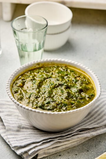 Punjabi Saag served in a bowl, garnished with ginger juliennes.