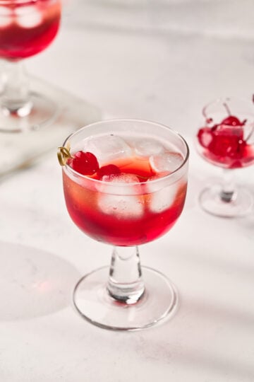 Classic Shirley Temple Drink served in a tall glass with ice, grenadine, and maraschino cherry garnish.