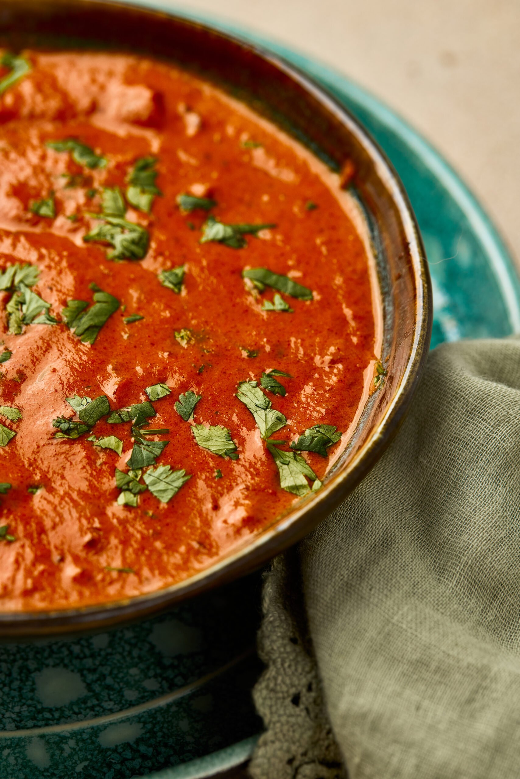 Close-up of Tikka Masala Sauce showing smooth, creamy tomato curry with rich orange color.