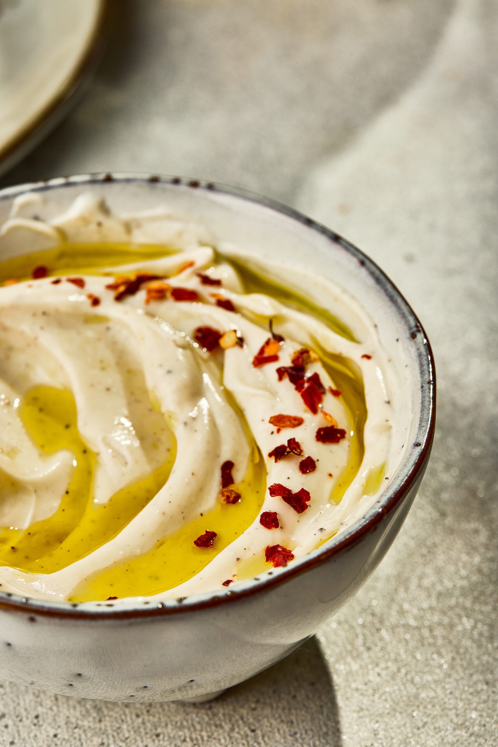 Close-up of Whipped Ricotta showing silky, creamy texture with olive oil swirl.