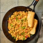 Egg Bhurji served in a bowl, garnished with fresh coriander and paired with buttered pav bread.