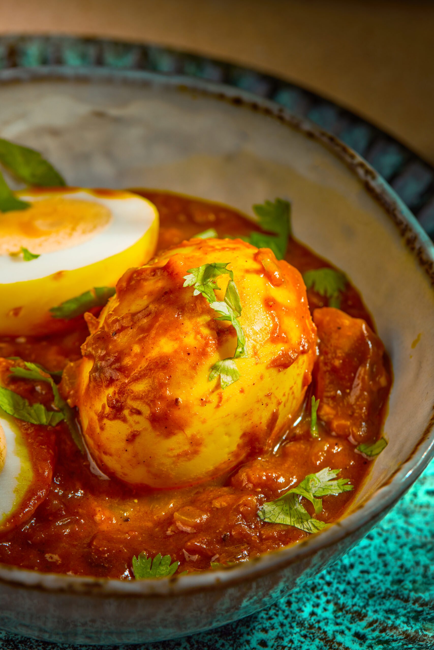 Close-up of Egg Pulusu showing boiled eggs coated in thick tamarind-spiced gravy.