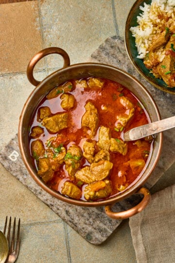 Mutton Curry served in a bowl with rich spiced gravy, garnished with fresh coriander leaves.