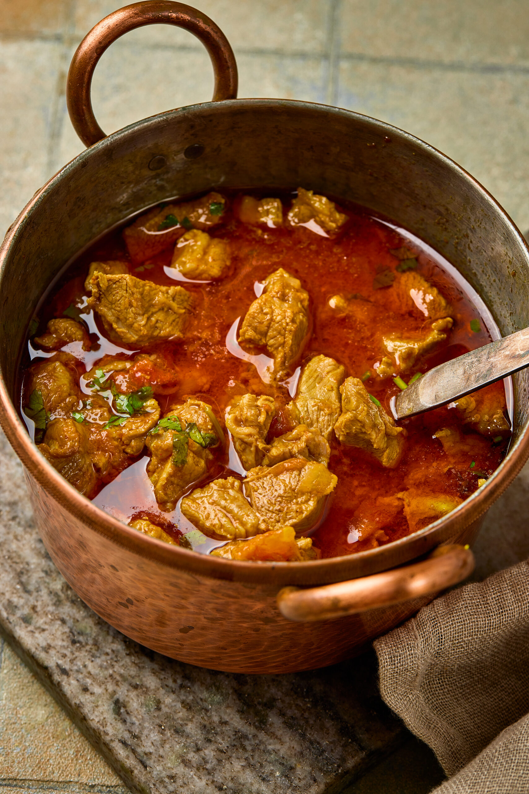 Close-up of Mutton Curry showing tender meat pieces in thick, aromatic gravy.