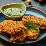 Sesame-Crusted Paneer Fingers served on a platter with golden crust and dipping sauce on the side.