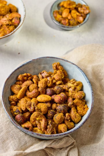 Spiced Nuts served in a bowl, coated with chili, cumin, and honey glaze for a sweet and savory flavor.