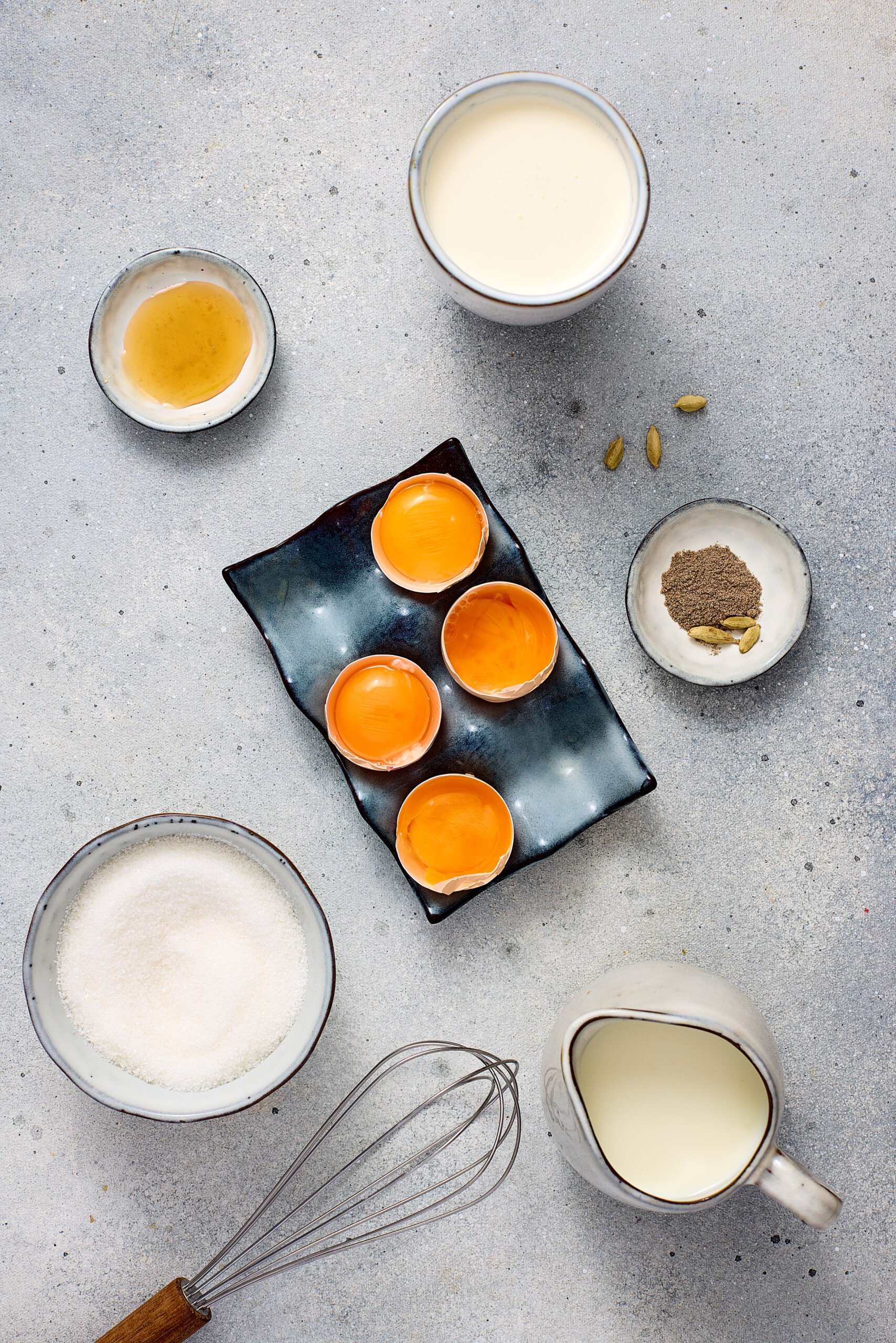 Ingredients for cardamom crème brûlée arranged on a counter.