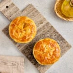 Curry pot pie served in a ramekin on a wooden board