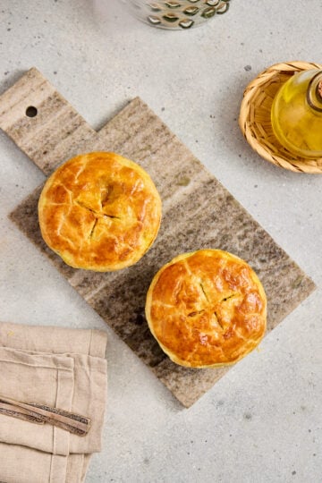Curry pot pie served in a ramekin on a wooden board