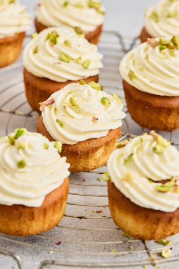 Gulab jamun cupcakes topped with cream frosting and pistachios