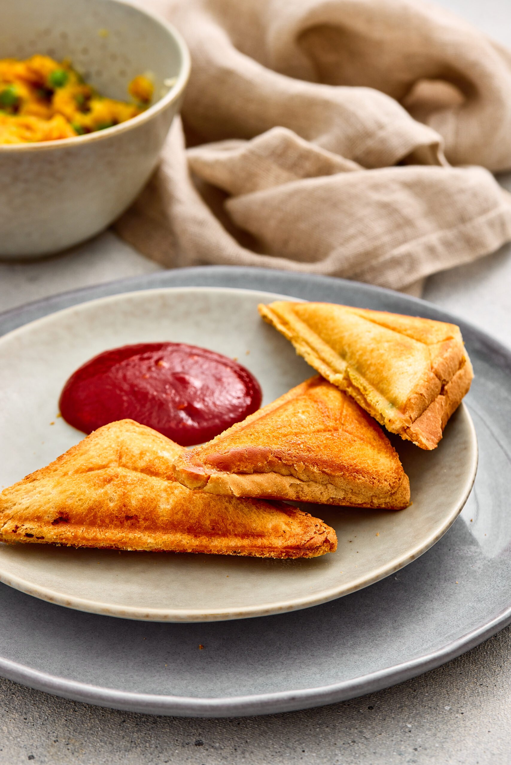 Crispy Samosa Toasties cut into triangles and served on a plate.