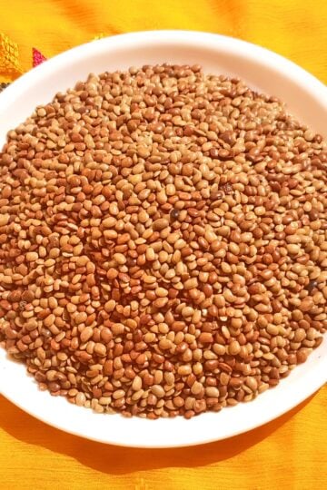 Kulthi dal (horse gram) in a bowl with whole brown lentils.