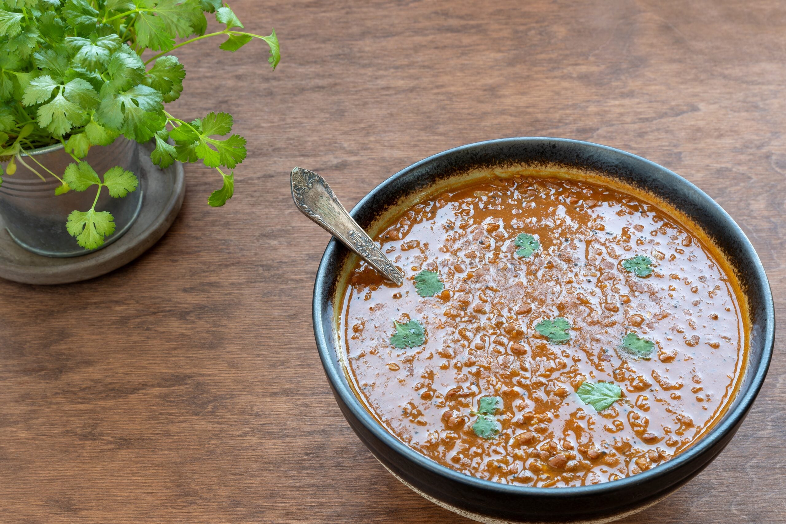 Kulthi dal (Horse Gram) in a bowl garnished with fresh coriander leaves.