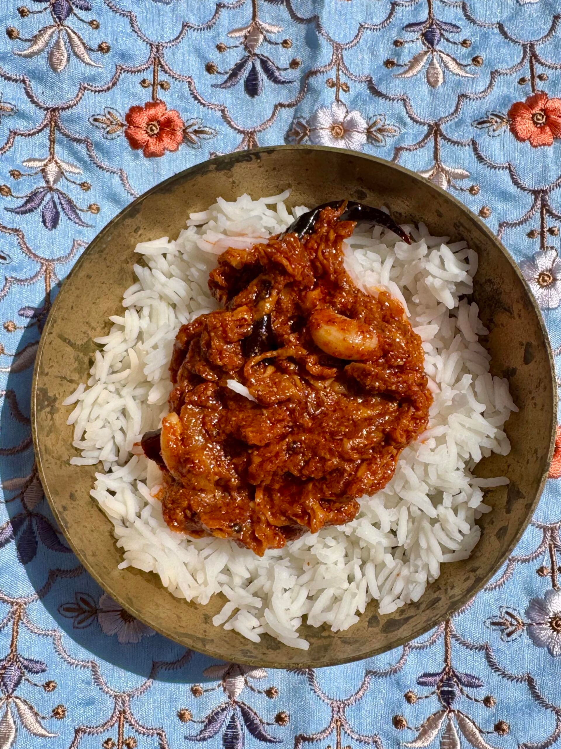Mango thokku pickle ready to serve with rice in a bowl.